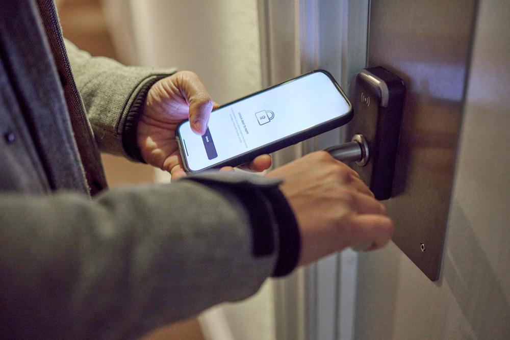 Man låser upp dörr genom en digital nyckel på sin telefon